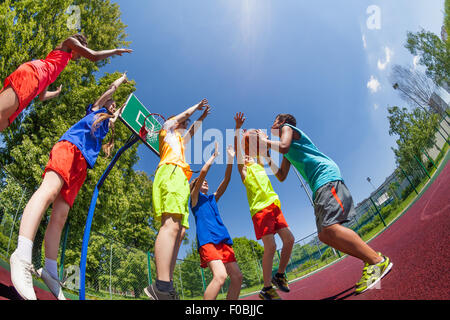 Fisheye view from below of teens during basketball Stock Photo