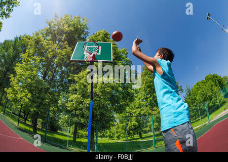 Arabian boy throws ball in basketball goal Stock Photo