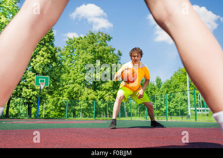 Boy with ball going to player at basketball Stock Photo