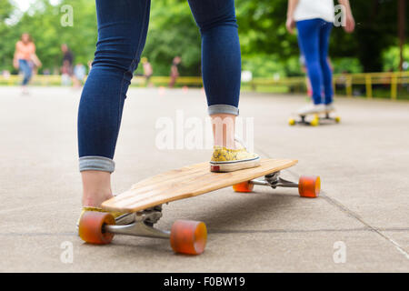 Teenage girl practicing riding long board. Stock Photo