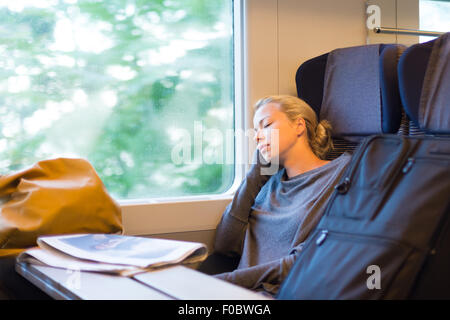 Lady traveling napping on a train. Stock Photo