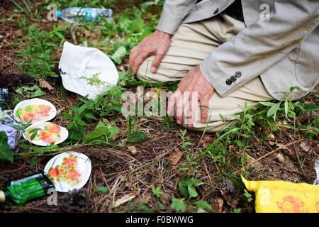 Mudanjiang City, China. 11th Aug, 2015. 73-year-old Japanese Yohachi Nakajima, a 'war orphan' left in China after WWII, kneels down in front of the tomb of his adoptive parents in Mudanjiang City, northeast China's Heilongjiang Province, Aug. 10, 2015. Nakajima went to northeast China's Heilongjiang province in 1942 with his family as members of 'the Japanese settlers group' when he was only a one-year-old baby. But in 1945, when the militaristic Japan surrendered at the end of World War II, he was left in China solely. Credit:  Xinhua/Alamy Live News Stock Photo