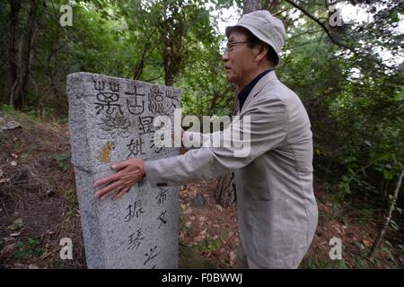 Mudanjiang City, China. 11th Aug, 2015. 73-year-old Japanese Yohachi Nakajima, a 'war orphan' left in China after WWII, weeps as he watches the tomb of his adoptive parents in Mudanjiang City, northeast China's Heilongjiang Province, Aug. 10, 2015. Nakajima went to northeast China's Heilongjiang province in 1942 with his family as members of 'the Japanese settlers group' when he was only a one-year-old baby. But in 1945, when the militaristic Japan surrendered at the end of World War II, he was left in China solely. Credit:  Xinhua/Alamy Live News Stock Photo