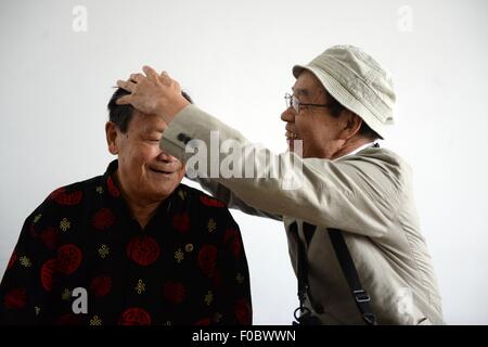 Mudanjiang City, China. 11th Aug, 2015. 73-year-old Japanese Yohachi Nakajima (R), a 'war orphan' left in China after WWII, reunions with his Chinese teacher in Mudanjiang City, northeast China's Heilongjiang Province, Aug. 11, 2015. Nakajima went to northeast China's Heilongjiang province in 1942 with his family as members of 'the Japanese settlers group' when he was only a one-year-old baby. But in 1945, when the militaristic Japan surrendered at the end of World War II, he was left in China solely. Credit:  Xinhua/Alamy Live News Stock Photo