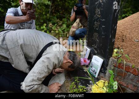 Mudanjiang City, China. 11th Aug, 2015. 73-year-old Japanese Yohachi Nakajima, a 'war orphan' left in China after WWII, mourns in front of the tomb of his adoptive parents in Mudanjiang City, northeast China's Heilongjiang Province, Aug. 11, 2015. Nakajima went to northeast China's Heilongjiang province in 1942 with his family as members of 'the Japanese settlers group' when he was only a one-year-old baby. But in 1945, when the militaristic Japan surrendered at the end of World War II, he was left in China solely. Credit:  Xinhua/Alamy Live News Stock Photo