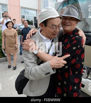 Mudanjiang City, China. 11th Aug, 2015. 73-year-old Japanese Yohachi Nakajima (L), a 'war orphan' left in China after WWII, hugs his Chinese teacher in Mudanjiang City, northeast China's Heilongjiang Province, Aug. 11, 2015. Nakajima went to northeast China's Heilongjiang province in 1942 with his family as members of 'the Japanese settlers group' when he was only a one-year-old baby. But in 1945, when the militaristic Japan surrendered at the end of World War II, he was left in China solely. Credit:  Xinhua/Alamy Live News Stock Photo