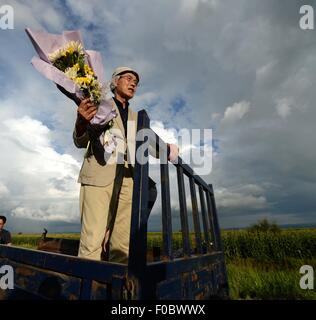 Mudanjiang City, China. 11th Aug, 2015. 73-year-old Japanese Yohachi Nakajima (R), a 'war orphan' left in China after WWII, arrives at the site of the grave of his adoptive parents in Mudanjiang City, northeast China's Heilongjiang Province, Aug. 10, 2015. Nakajima went to northeast China's Heilongjiang province in 1942 with his family as members of 'the Japanese settlers group' when he was only a one-year-old baby. But in 1945, when the militaristic Japan surrendered at the end of World War II, he was left in China solely. Credit:  Xinhua/Alamy Live News Stock Photo