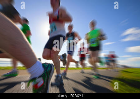 Marathon runners on the bank of ocean bay, blurred motion Stock Photo