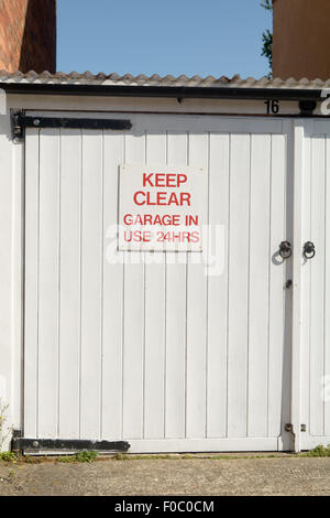 Keep Clear Garage in Use 24 Hours sign on garage door Stock Photo