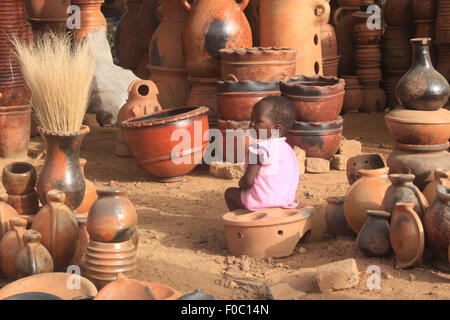 BANDIAGARA, MALI - OCTOBER 5, 2008:  Unidentified little girl in a pottery shop in bandiagara in the Mopti region in Mali Stock Photo