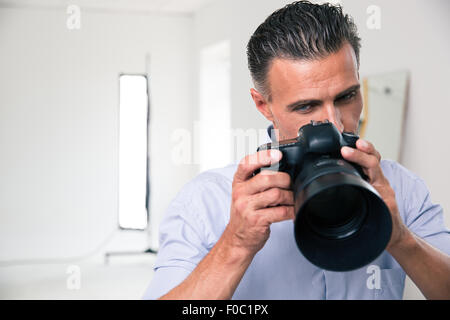 Portrait of a young photographer using camera in studio Stock Photo