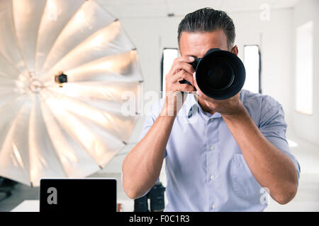 Photographer making photo on camera in studio Stock Photo