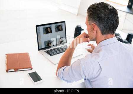 Back view portrait of a young man using laptop at his workplace Stock Photo