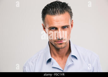 Portrait of a handsome young man looking at camera over gray background Stock Photo