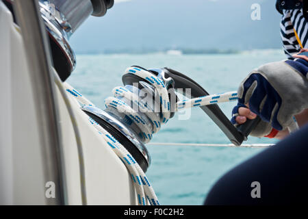 Winch and sailors hands on a sailboat. Shot with a selective focus Stock Photo