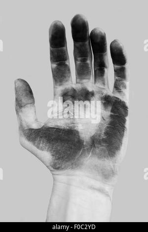 Close-up of dirty hand over gray background Stock Photo