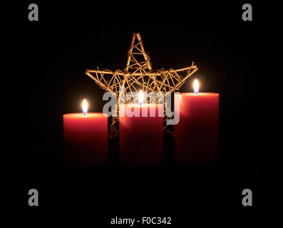 Lit red candles & star of David on a dark wooden floor with black background. Stock Photo