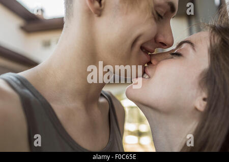 Side view of passionate woman biting man's chin Stock Photo