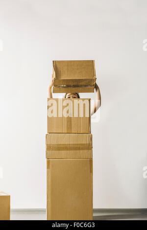 Girl stacking boxes against white background Stock Photo