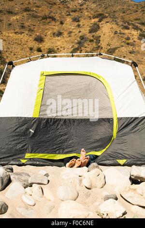 Couple's feet sticking out of tent, Malibu, California, USA Stock Photo