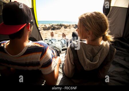 Couple relaxing inside tent on beach, Malibu, California, USA Stock Photo