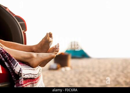 Couple relaxing inside vehicle on beach Stock Photo