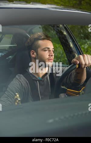 Portrait of man driving looking through windscreen Stock Photo