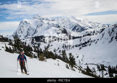 Young male skier moving along mountainside, Mount Baker, Washington, USA Stock Photo