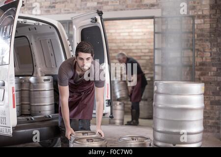 Brewers loading kegs into back of van Stock Photo