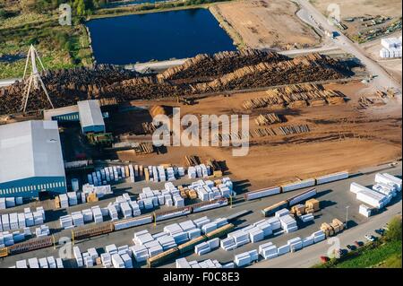 Aerial view of stacked tree trunks and warehouses in timber yard Stock Photo