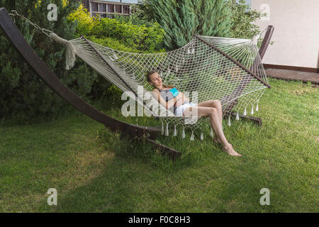 Young woman sleeping in hammock outdoors Stock Photo