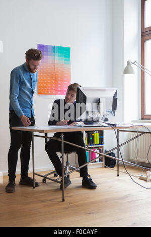 Businessmen discussing at desk in office Stock Photo