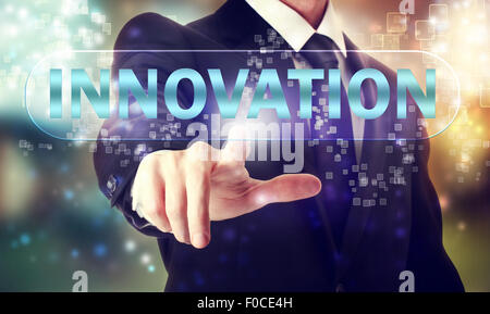 Businessman pressing INNOVATION button on touch screen Stock Photo