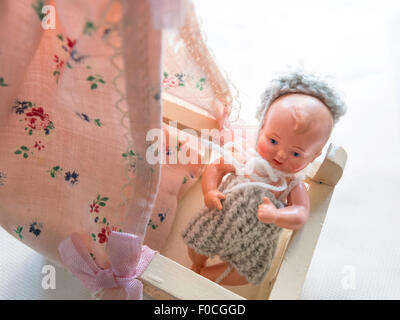 Vintage Miniature Baby Doll in Crib Stock Photo