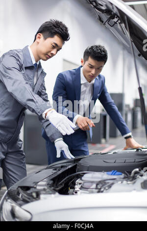 Auto mechanic talking with car owner Stock Photo