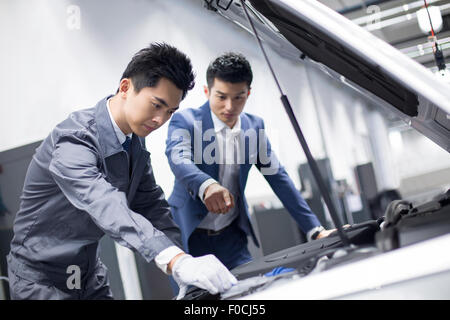Auto mechanic talking with car owner Stock Photo