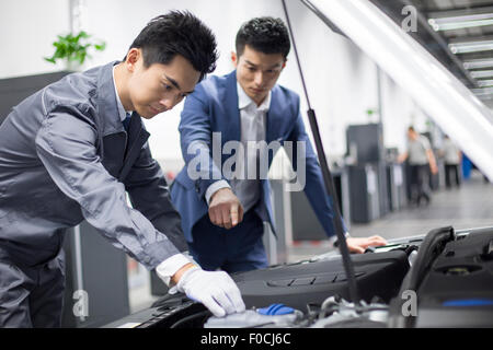 Auto mechanic talking with car owner Stock Photo