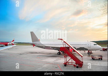 Airplaine at airport in the beautiful sunrise. Stock Photo