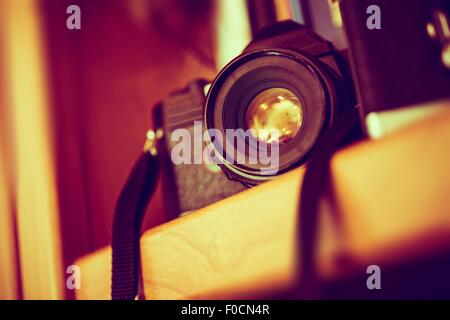 Vintage Film Camera on a Bookshelf. Aged Camera Closeup. Photography Technologies. Stock Photo