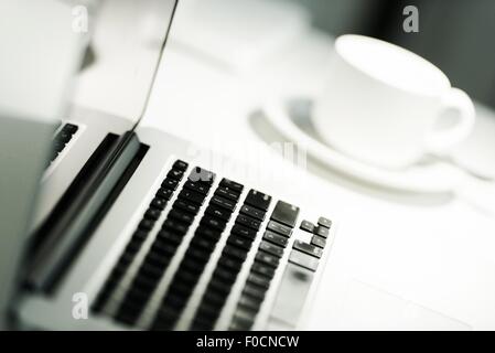Computer and Coffee Cup. Modern Mobile Workstation. Stock Photo