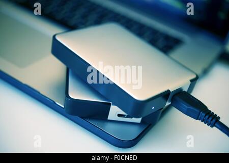 Portable Hard Drives Backup System. Two Portable Hard Drives on the Laptop Closeup Photo. Stock Photo