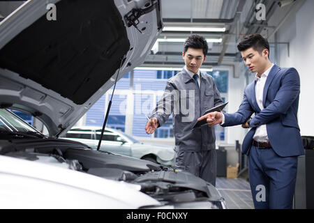 Auto mechanic talking with car owner Stock Photo