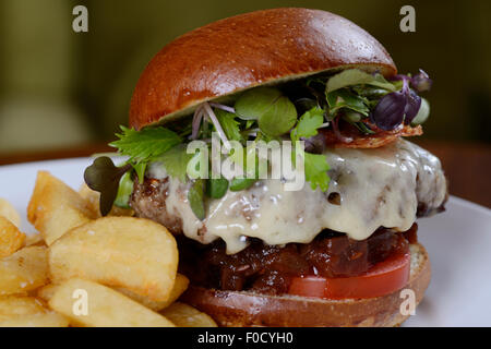 Prime steak burger served with thick cut chips Stock Photo