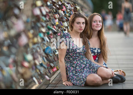 Two young girls sitting on a pedestrian bridge in Krakow. Stock Photo