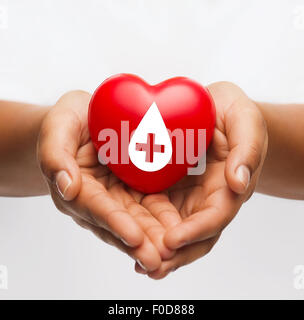 female hands holding red heart with donor sign Stock Photo