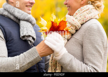 smiling couple with maple leaves in autumn park Stock Photo