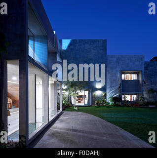 Front and facade elevation with garden at dusk. Marbled House, Ahmedabad, India. Architect: Matharoo Associates, 2015. Stock Photo