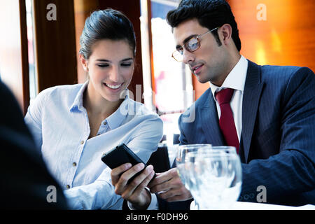 Close up portrait of young business partners reviewing work at lunch. Stock Photo