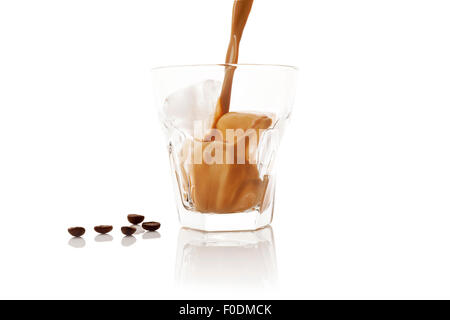 Ice coffee. Pouring ice coffee into glass with ice isolated on white background. Delicious coffee drinking. Stock Photo