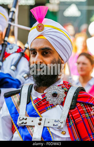 Glasgow, UK, 13th Aug, 2015. At Glasgow's annual Festival of Bagpipe music, 'Piping Live', which ends with the World Championship competition on Saturday 15th August, the National Pipe Band of Malaysia - 'The Sri Dasmesh Pipe Band' based in Kuala Lumpar, entertained the crowds in Buchanan Street and George Square, by playing a medley of Scottish bagpipe music on a sunny day in Scotland. Credit:  Findlay/Alamy Live News Stock Photo